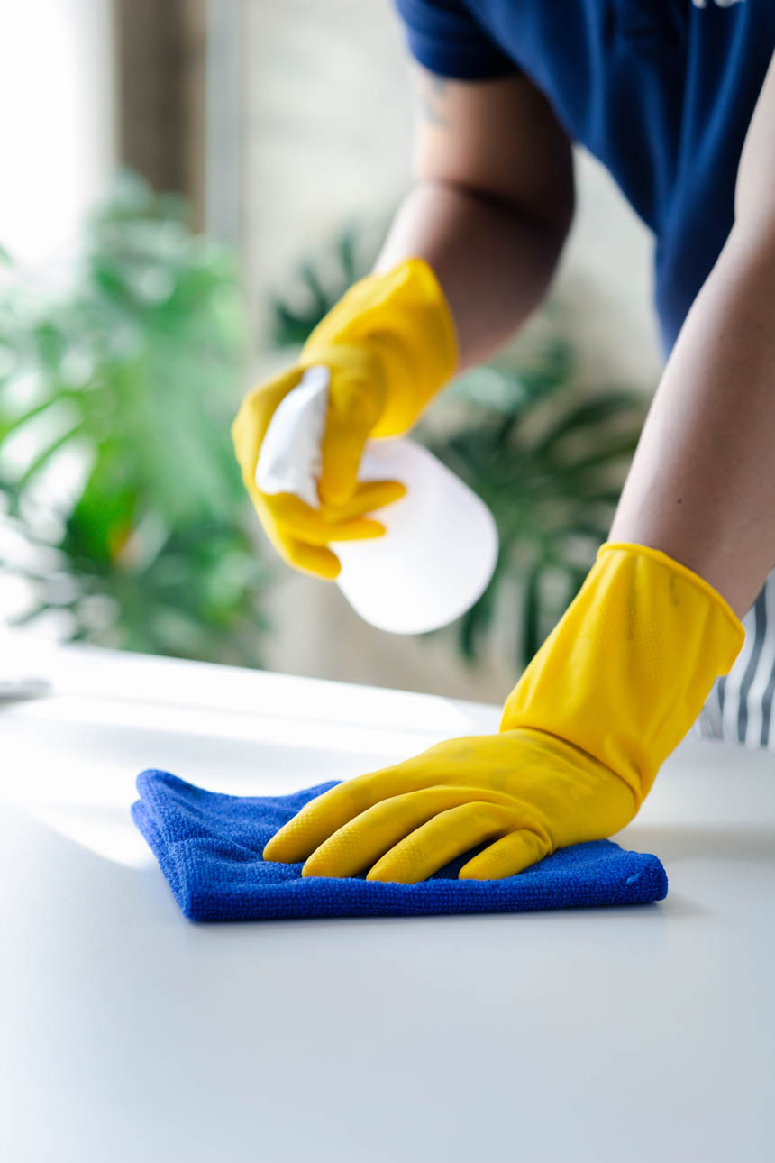 Person cleaning the room, cleaning staff is using cloth and spra Städföretag i Vara som städar badrum - Grundlig städning